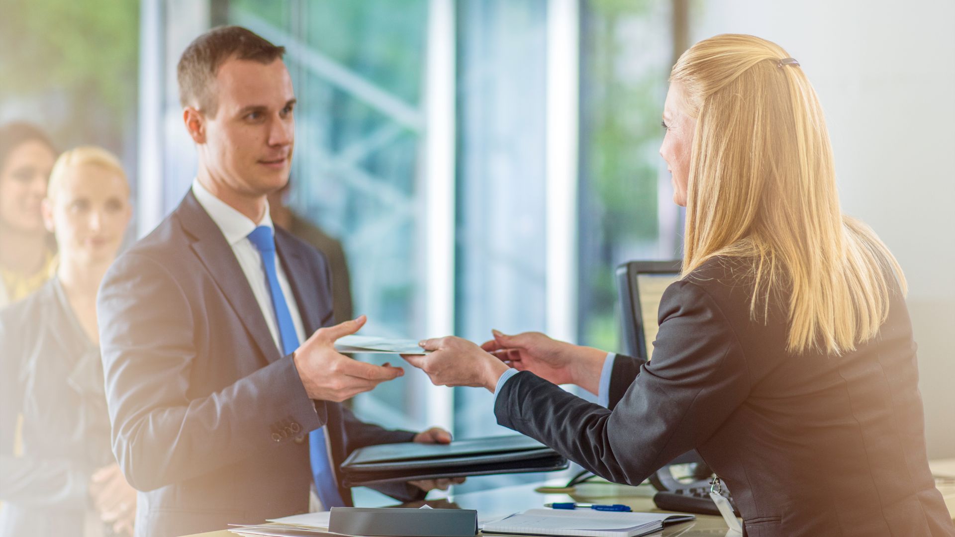 Customer speaking with a bank teller at a service counter, illustrating common English phrases used in banking scenarios.