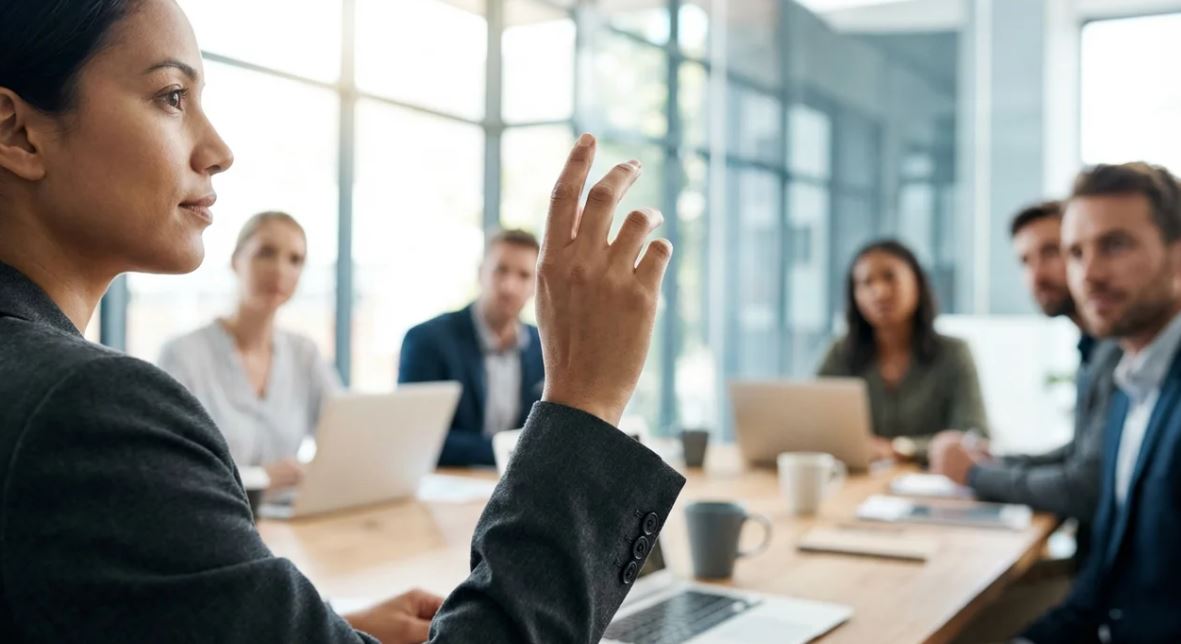 Confident professional interrupting and speaking clearly in a business meeting.