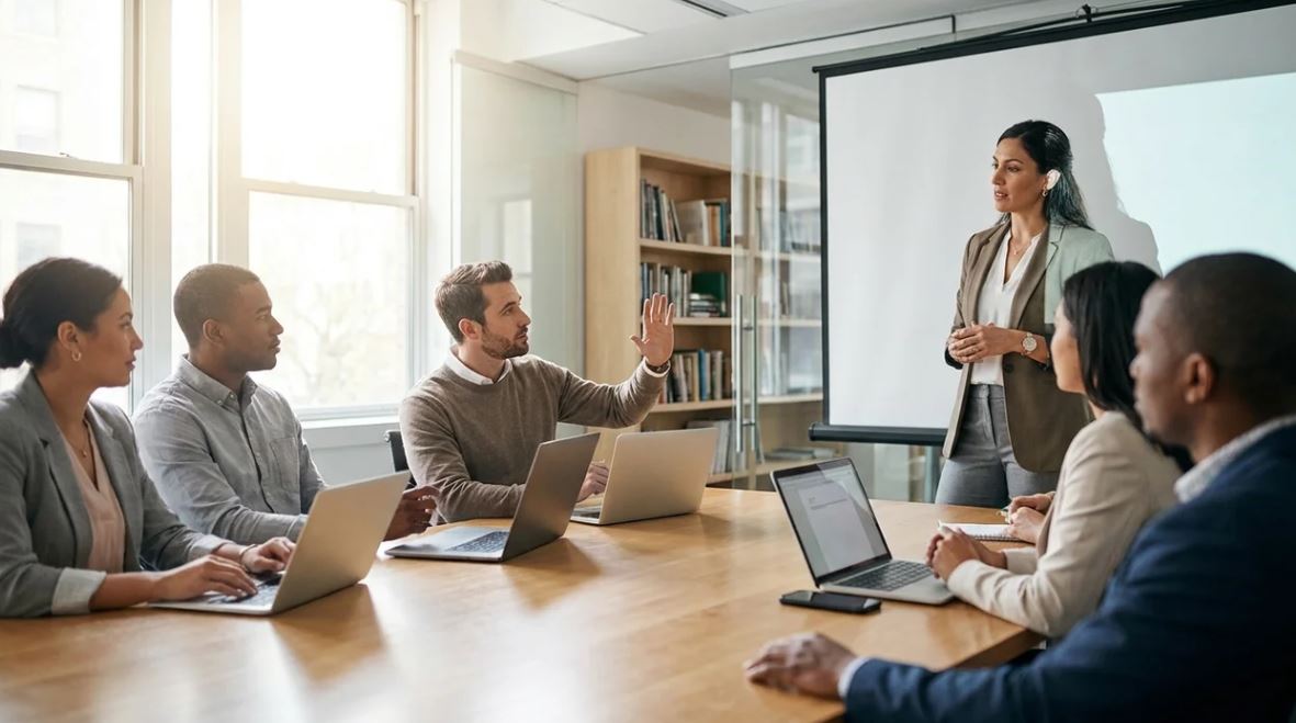 Manager saying "let's take this offline" during meeting in modern workplace.