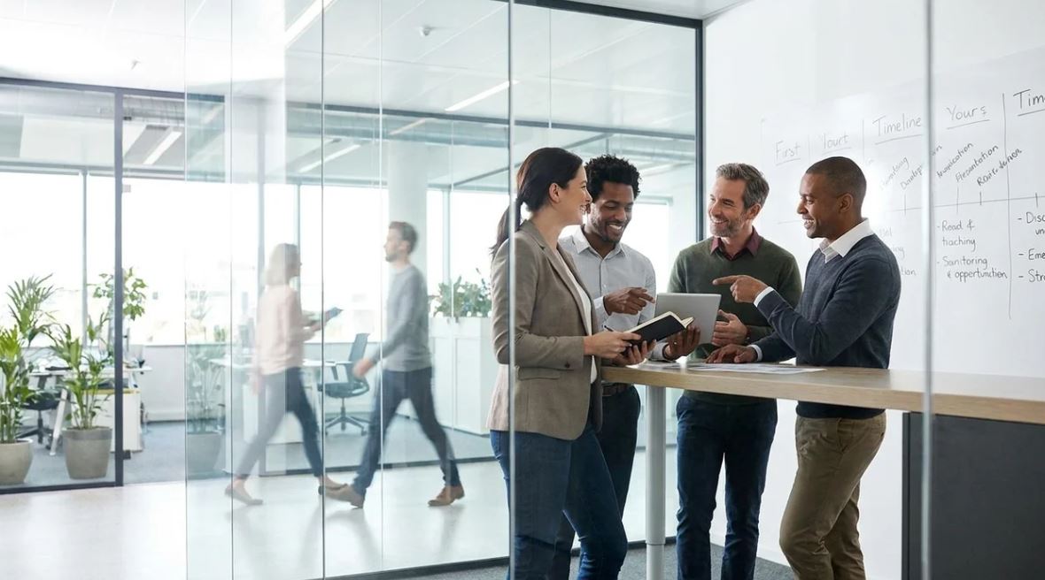Coworkers aligning on project timeline in professional office conversation.