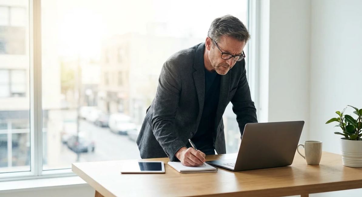 Employee reviewing document carefully after saying “I assume” to ensure accuracy in professional communication.