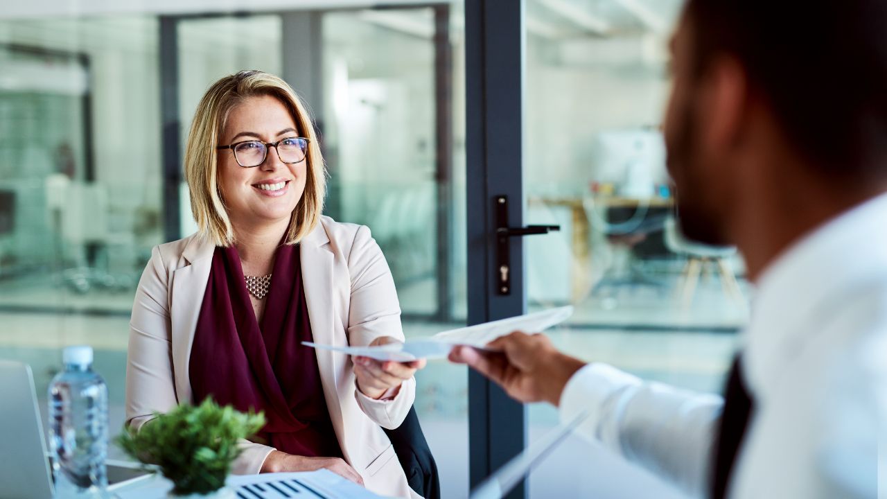 Customer speaking with a service representative at a counter, requesting a refund for a faulty product.